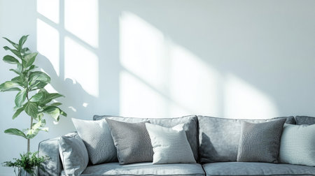 Living room interior with a gray fabric sofa and decorative pillows against a white wall, bright sunlight streaming in, free space on the left for mock-up designの素材