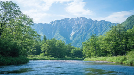The peaceful Azusa River flowing through Kamikachi, framed by fresh green trees and the towering peaks of the Hotaka Mountains in the distance.の素材
