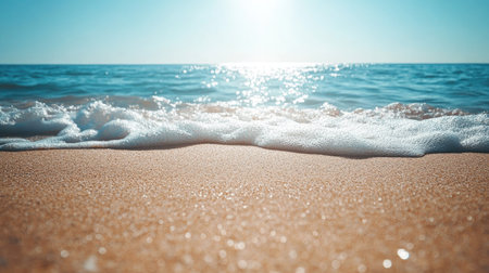Fine beach sand in the foreground, leading to the gently rolling waves of the sea in the background under the bright summer sun. Ideal for a coastal vacation scene.の素材