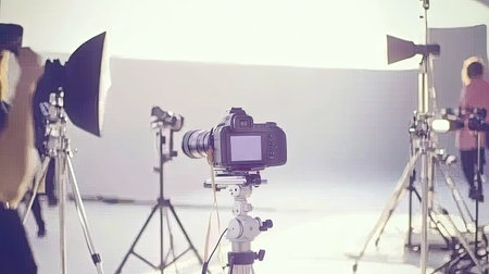 A high-end cinema camera on a dolly track, surrounded by lighting fixtures and crew members, capturing the essence of professional filmmaking on set. --chaos 70の素材