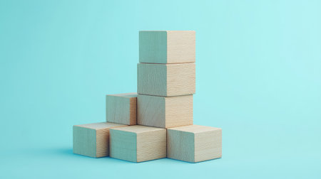 Wooden blocks in a stair formation on a light blue background, demonstrating a clear path to business growth. Plenty of empty space for promotional text or logos.の素材