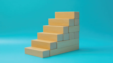 Wooden blocks arranged as a staircase on a blue backdrop, representing business development and success. A minimalist, modern design with open copy space.の素材