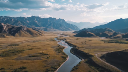 This stunning aerial view showcases a serene mountain valley with a meandering river, surrounded by majestic peaks under a beautiful sky. Perfect for nature themes.の素材