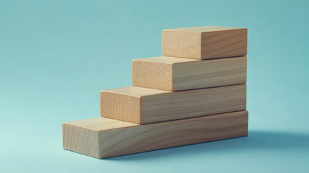 Stacked wooden blocks on a blue paper surface, forming a clear step-by-step visual for business growth. Ideal for presentations with available copy space.の素材
