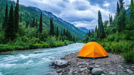 A vibrant orange tent sits peacefully by a serene mountain river, surrounded by lush forests and majestic peaks, perfect for nature lovers and adventurers.の素材