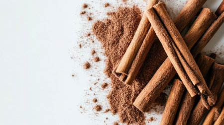 Beautiful arrangement of cinnamon sticks and ground powder on a bright surface, showcasing the spice's rich texture and warm color, perfect for culinary use.の素材