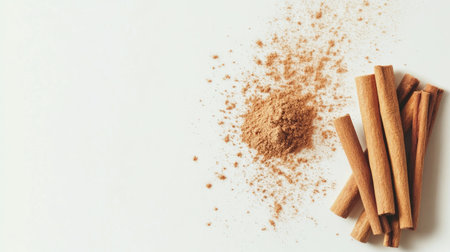 Ground cinnamon and cinnamon sticks arranged on a white background, showcasing the warm tones and textures of this popular spice used in cooking and baking.の素材