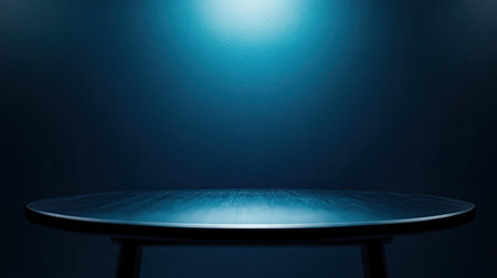 Smooth blue wall background with a reflective table and blurry spotlight for presenting winter-themed cosmetics or food items.の素材
