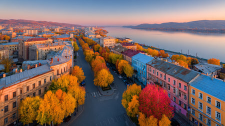 A breathtaking aerial view of a city during autumn showcases vibrant foliage and a tranquil river. The colorful landscape invites exploration and serenity.の素材