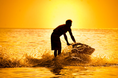 man drive jet ski at sunset.の写真素材