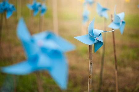 Paper windmills in green grass field.の写真素材