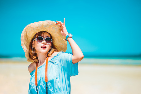 smiling young woman in sun hat on beach over sea and blue sky background.copy spaceの写真素材