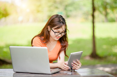 Young beautiful Asian woman working at outdoor park,happy relaxing. owner business woman work  at outdoor park.internet and technology concept.の写真素材