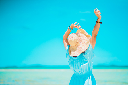 summer holidays, vacation, travel and people concept - smiling young woman in sun hat on beach over sea and blue sky background.copy spaceの写真素材