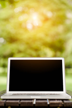 Conceptual work space, Laptop computer with blank screen on table, blurred background.の写真素材