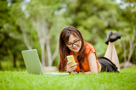 Young beautiful Asian woman working at outdoor park,happy relaxing. owner business woman work  at outdoor park.internet and technology concept.の写真素材