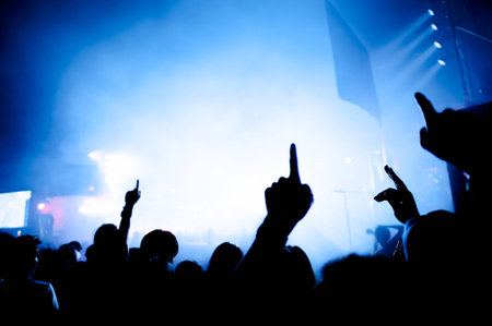 silhouettes of hand in concert.Light from the stage.の写真素材