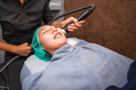 Young beautiful girl in mask for face relaxing in spa salon.の写真素材