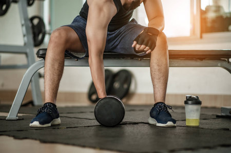 Bodybuilder working out with dumbbell weights at the gym.handsome power athletic man bodybuilder doing exercises with dumbbell. Fitness muscular bodyの写真素材