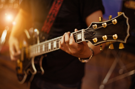 man playing guitar on a stage musical concert close-up view.guitarist plays.の写真素材