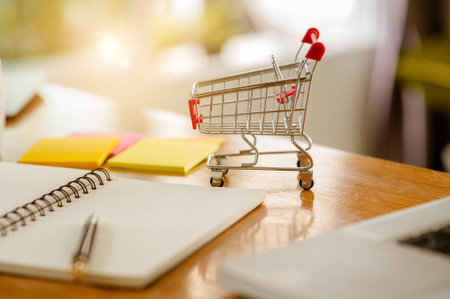 shopping concept - Empty Shopping Cart, laptop, on rustic wooden background.の写真素材