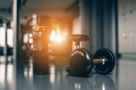 two dumbbells for fitness and protein cocktail in a shaker in a gym. Sports nutrition conceptの写真素材