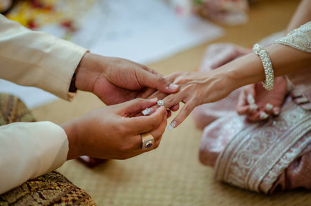 Close up Groom Put the Wedding Ring on bride in Thailand.の写真素材