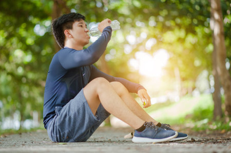 Asians man drinks water in the park.の写真素材