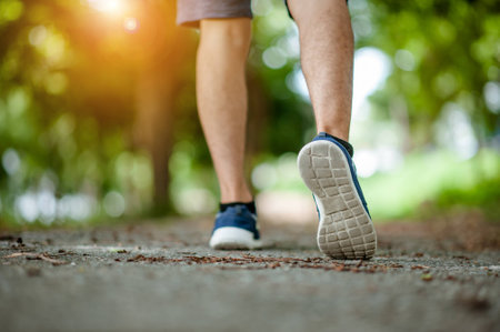 Close up shot of runner's shoes.A person running outdoors on a sunny day. Only the feet are visible. The person is wearing black running shoes.Exercise, fitness and healthy lifestyle.for copy space  .の写真素材