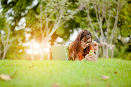 Young beautiful Asian woman working at outdoor park,happy relaxing. owner business woman work  at outdoor park.internet and technology concept.の写真素材