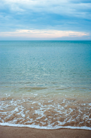 Peaceful beach background. Gold sand and turquoise sea water. Ocean coastline of nice soft sand and calm waves. Tropical vacation concept.の写真素材