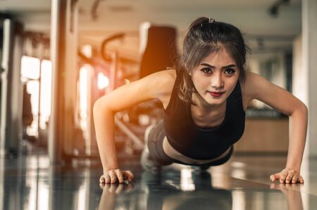 Young woman doing push-ups at the gym.