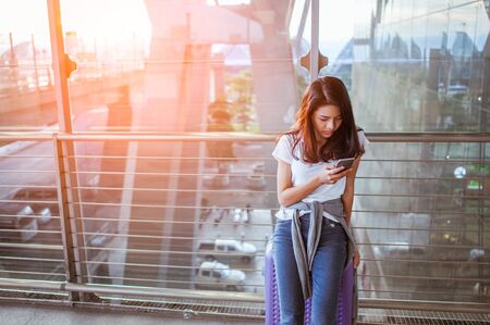 Women are using their smartphones to Flight Checking at airports.の写真素材