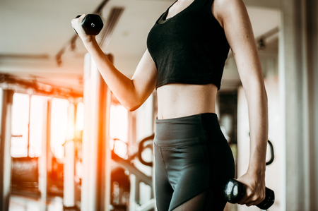 Young woman training with dumbbell in gym.exercising concept.fitness and healthy lifestyleの写真素材