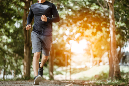 young man running in the nature. Healthy lifestyle.Active healthy runner jogging outdoor.Young Man Running In Wooded Forest Areaの写真素材