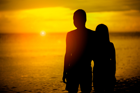 silhouette lovers at the beach with sunset.Couple in love having romantic tender moments at sunset.love and valentines concept.の写真素材