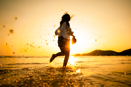 Woman Enjoying Beautiful Sunset on the Beachの写真素材