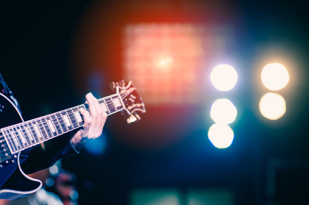 man playing guitar on a stage musical concert close-up view.guitarist plays.の写真素材