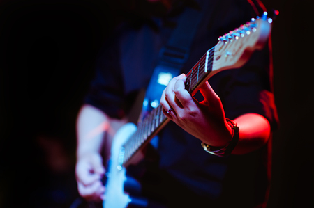 man playing guitar on a stage musical concert close-up view.guitarist plays.の写真素材