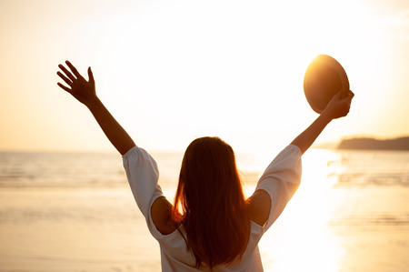 Woman Enjoying Beautiful Sunset on the Beachの写真素材