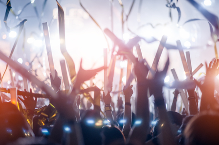 silhouettes of hand in concert.Light from the stage.confetti.the crowd of people silhouettes with their hands up.ribbonの写真素材