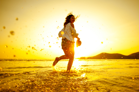 Woman Enjoying Beautiful Sunset on the Beachの写真素材
