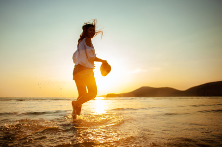 Woman Enjoying Beautiful Sunset on the Beachの写真素材