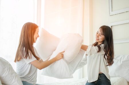 lesbian women at pillow fights in bedroom.の写真素材