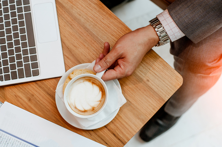 Businessman are using a laptop at the window and dink coffee.working on laptop, close up of hands of business man.の写真素材