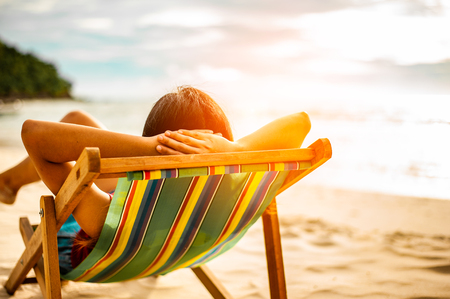 Woman relaxing on beach, looking at sea. Copy space.の写真素材