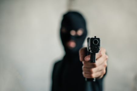 Robber with a gun robbing intimidate.Crime and robbery concept.の写真素材