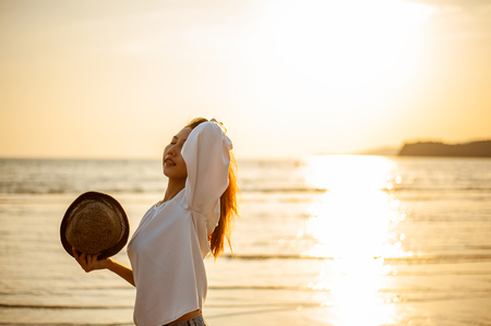 Woman Enjoying Beautiful Sunset on the Beachの写真素材