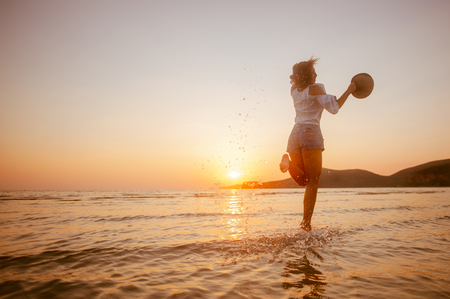 Woman Enjoying Beautiful Sunset on the Beachの写真素材