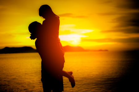 silhouette lovers at the beach with sunset.Couple in love having romantic tender moments at sunset.love and valentines concept.の写真素材